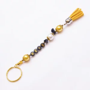 Sleutelhanger KEYS met letterkralen in goud en zwart en een geel kwastje