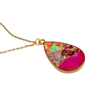 Druppelvormige resin hanger met holografische vlokken, roze glitter en steentjes in goudkleurige rand