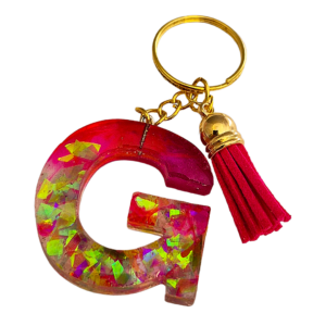 Letter sleutelhanger G in roze en paars met glittervlokken en rood kwastje