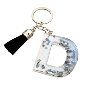 Letter sleutelhanger D van heldere resin met donkere zilvervlokken en zwart kwastje