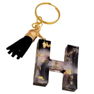Letter sleutelhanger H van zwarte resin met bladgoud en zwart kwastje